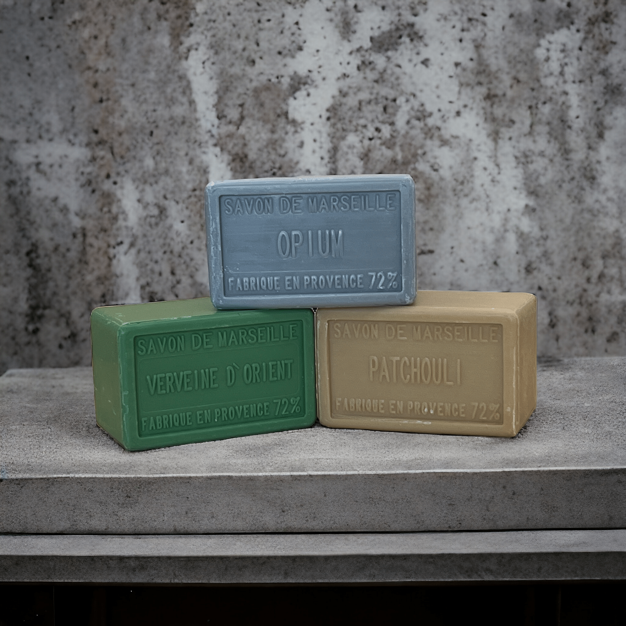 Three large soap bars on a marble shelf, Opium gret, Patchouli orange and Verbena green