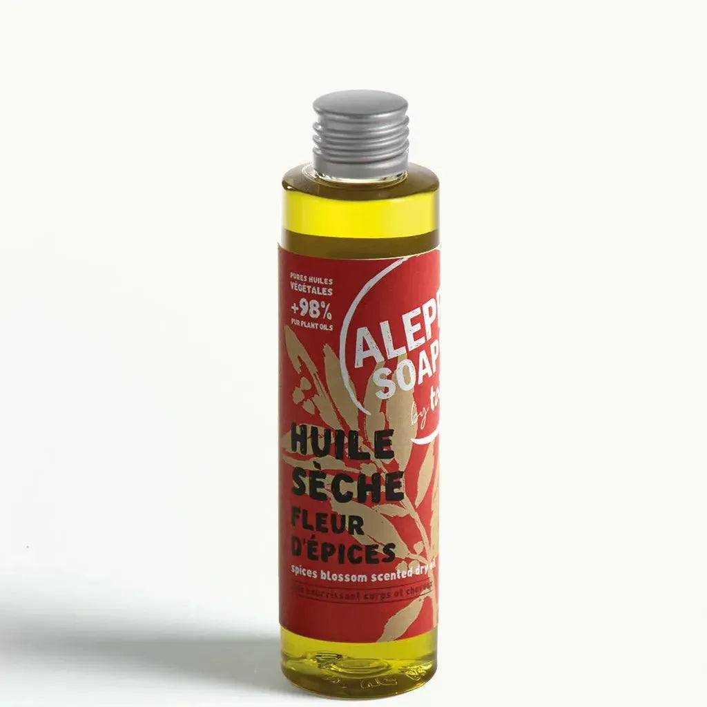 Bottle of Aleppo Soap Co dry oil with a red label on a white background