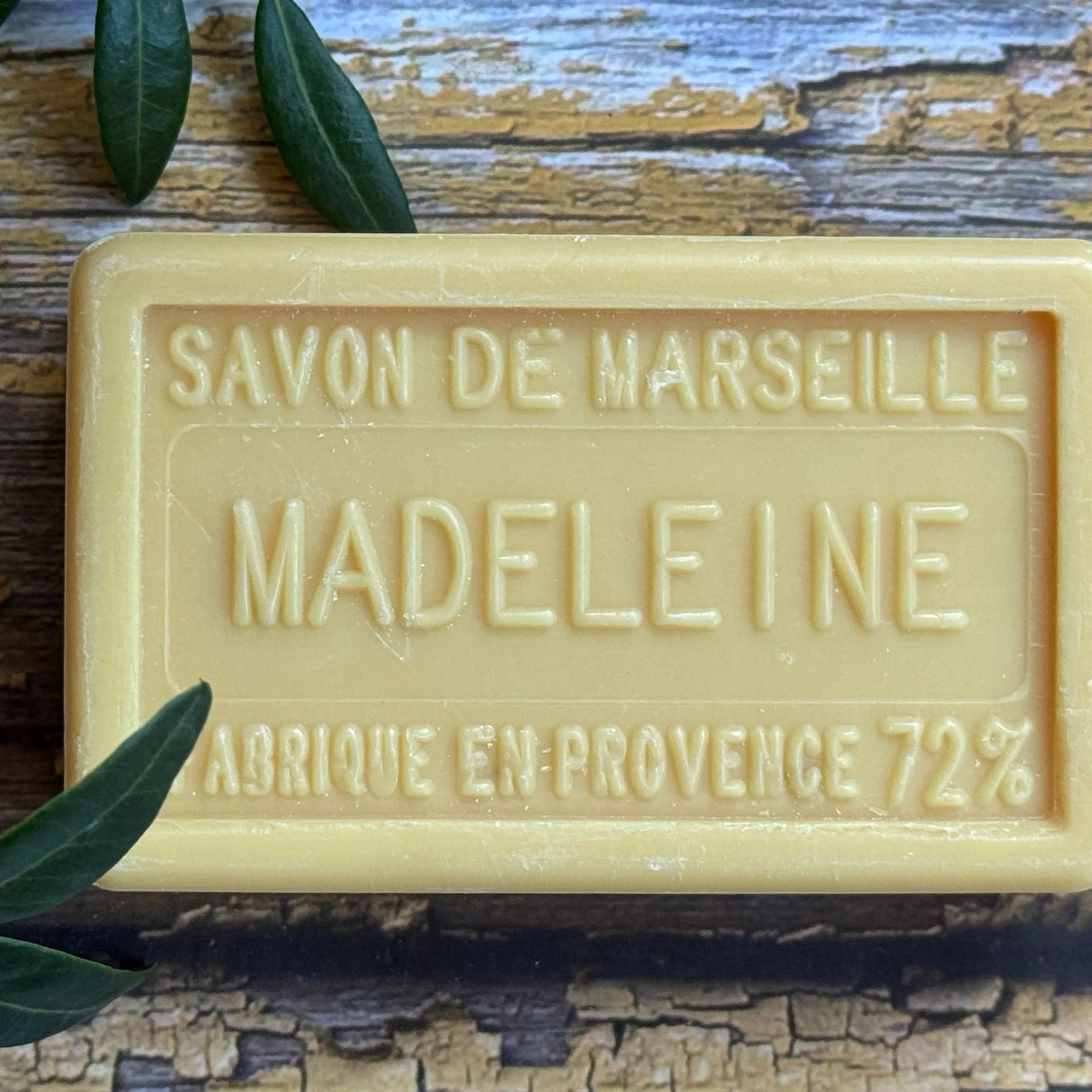 Bar of Savon de Marseille soap with 'Madeleine' branding on a wooden surface.