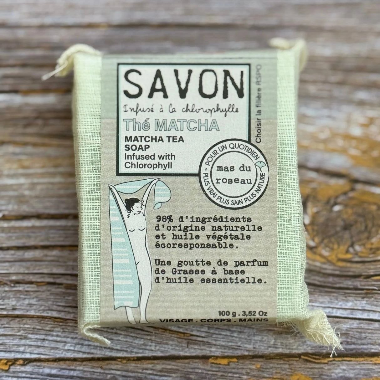 Bar of soap in a packaging with text on a wooden surface