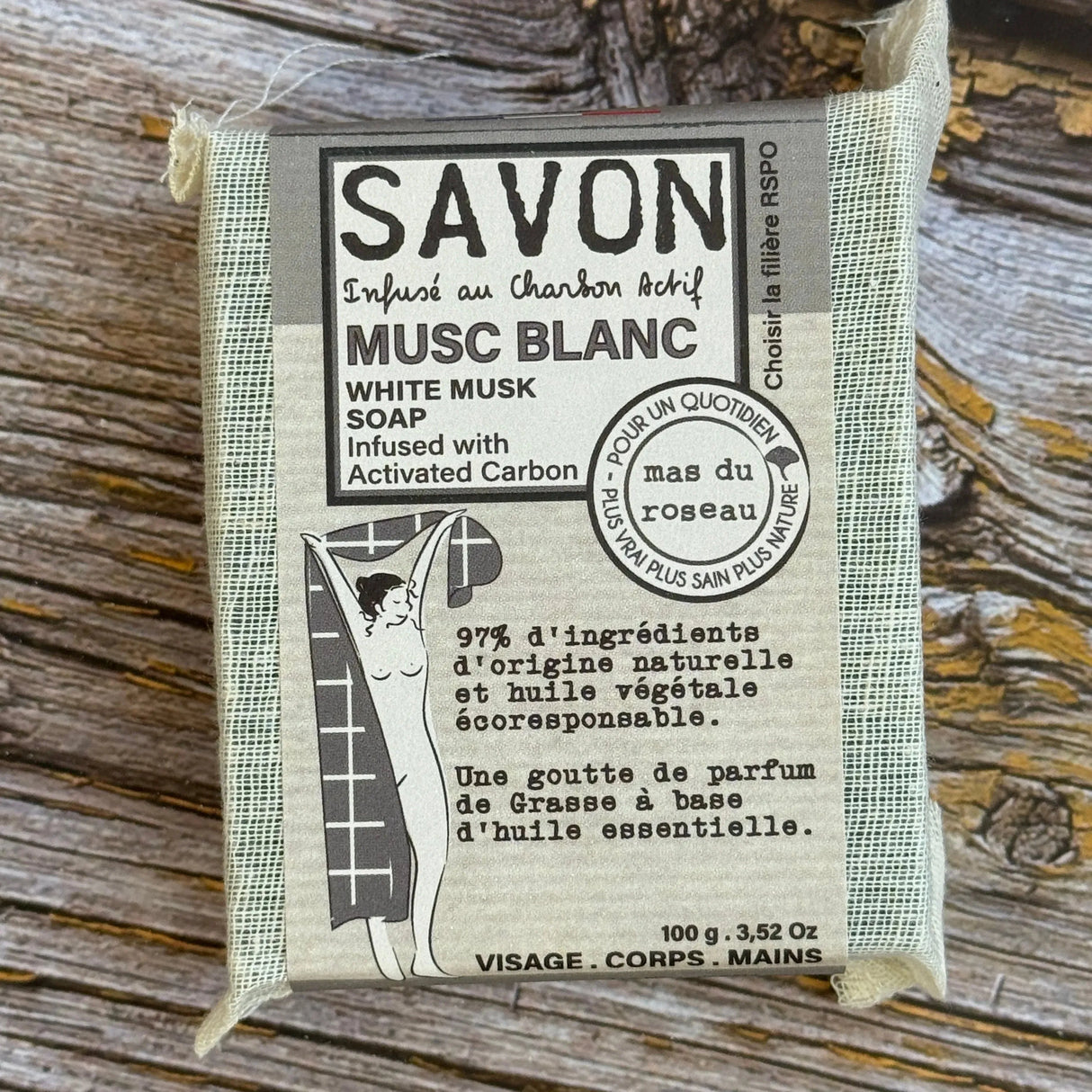 Bar of soap with packaging on a wooden surface