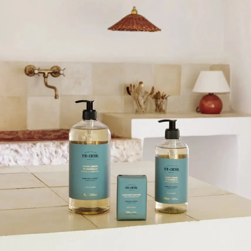 Bathroom setting with two bottles of soap and a small container on a counter.