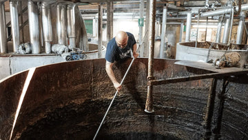 Stirring Olive Oil in a cauldron, soap making