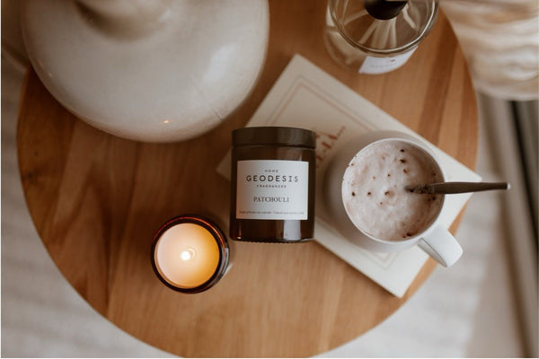 A lifestyle picture of a candle and cappuccino