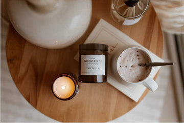 A lifestyle picture of a candle and cappuccino