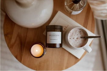 A lifestyle picture of a candle and cappuccino