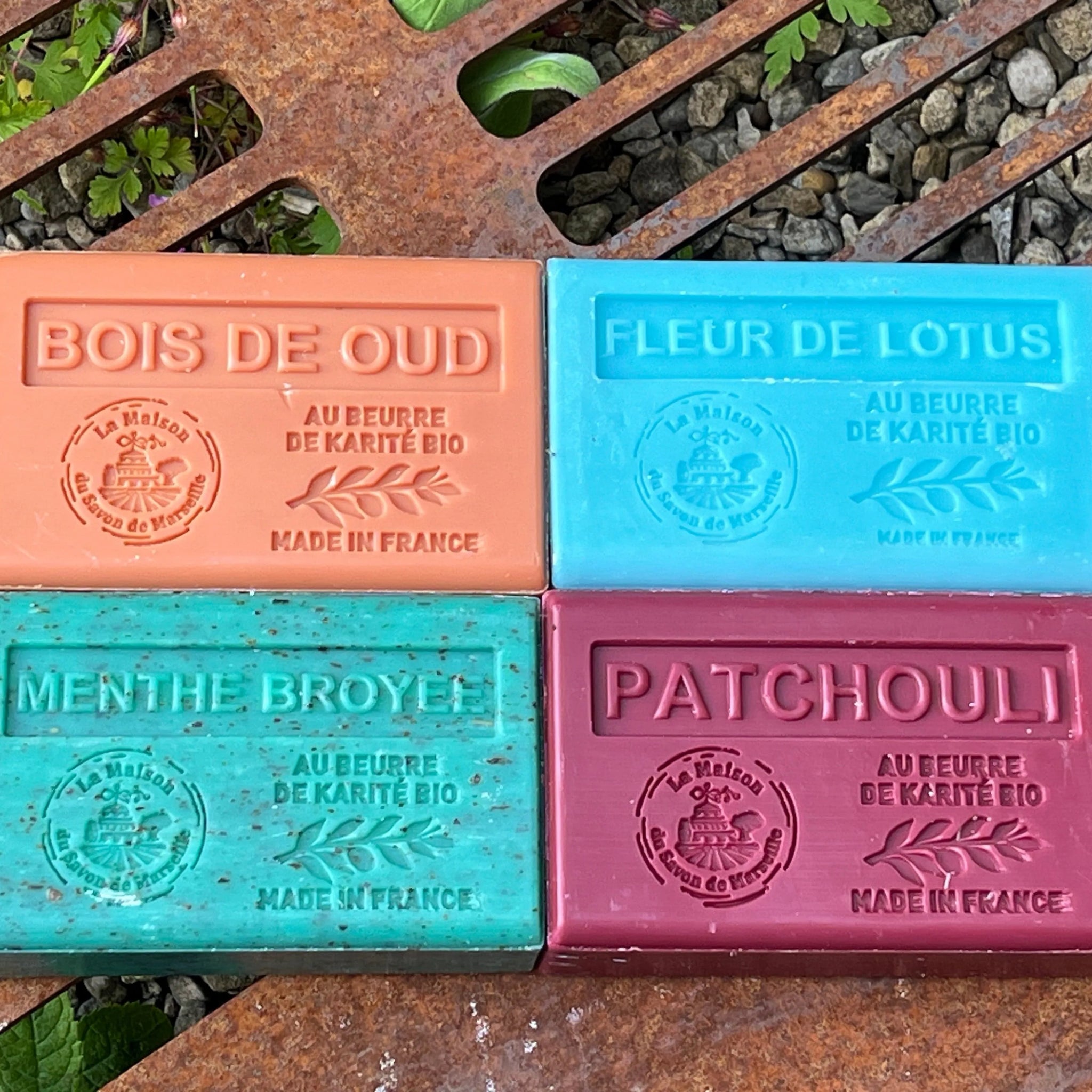 4 brightly coloured soap bars on a corten steel grill. Marseille Soaps UK