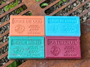 4 brightly coloured soap bars on a corten steel grill. Marseille Soaps UK