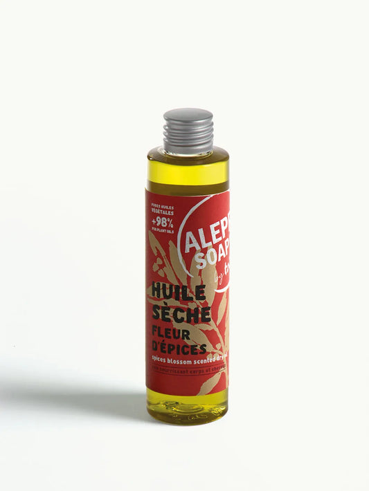 Bottle of Aleppo Soap Co dry oil with a red label on a white background