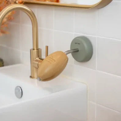 Olive Green Soap older with olive soap by by a sink with gold arc tap and mirror