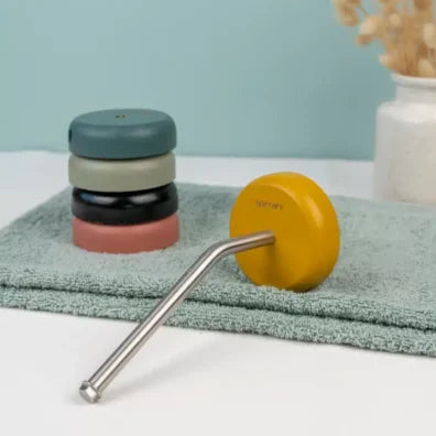 Stack of coloured round wooden bases with a stainless steel rod on an eau di nil towel