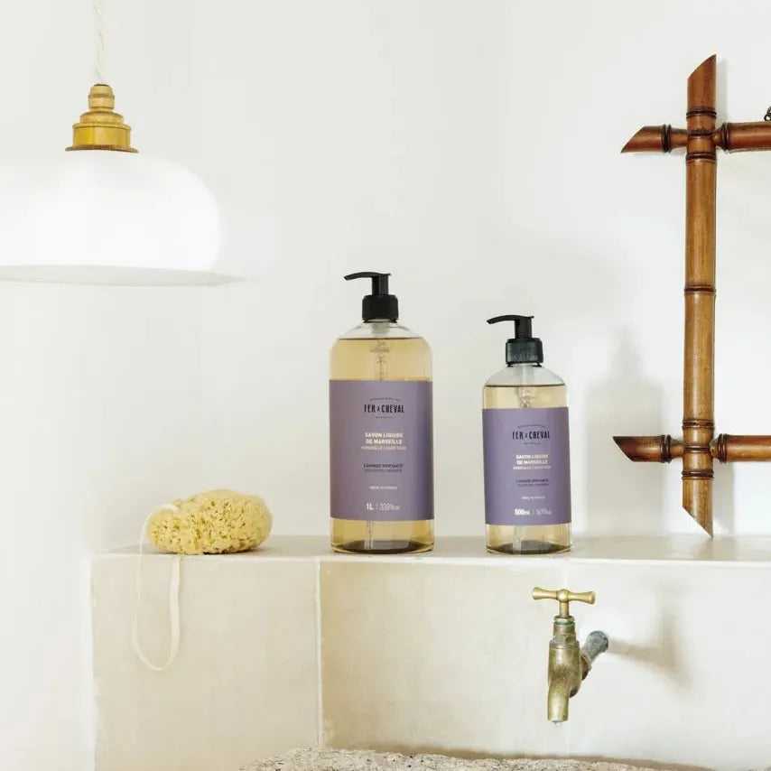 Bathroom setting with two bottles of soap on a shelf, a faucet, and a towel.