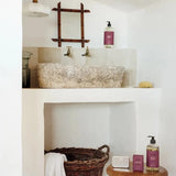 Bathroom with a sink, mirror, and various items on a shelf.