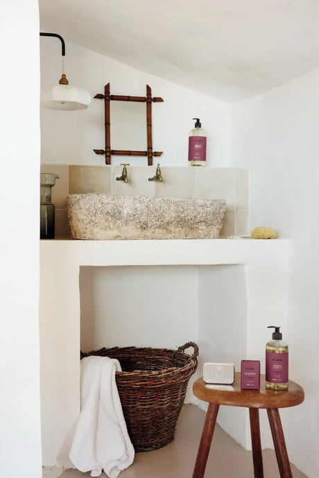 Bathroom with a sink, mirror, and various items on a shelf.