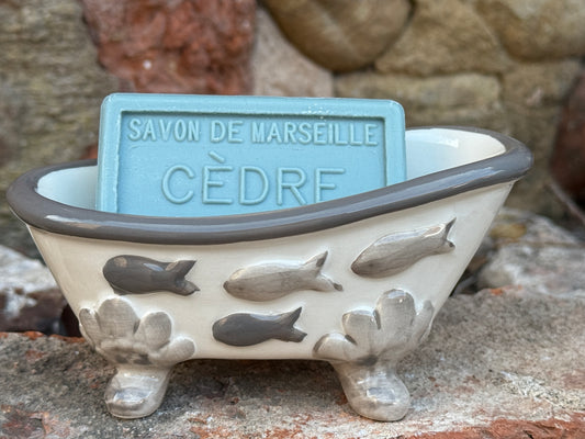 Decorative soap dish with a bar of soap labeled 'SAVON DE MARSEILLE Cedar' against a stone background.