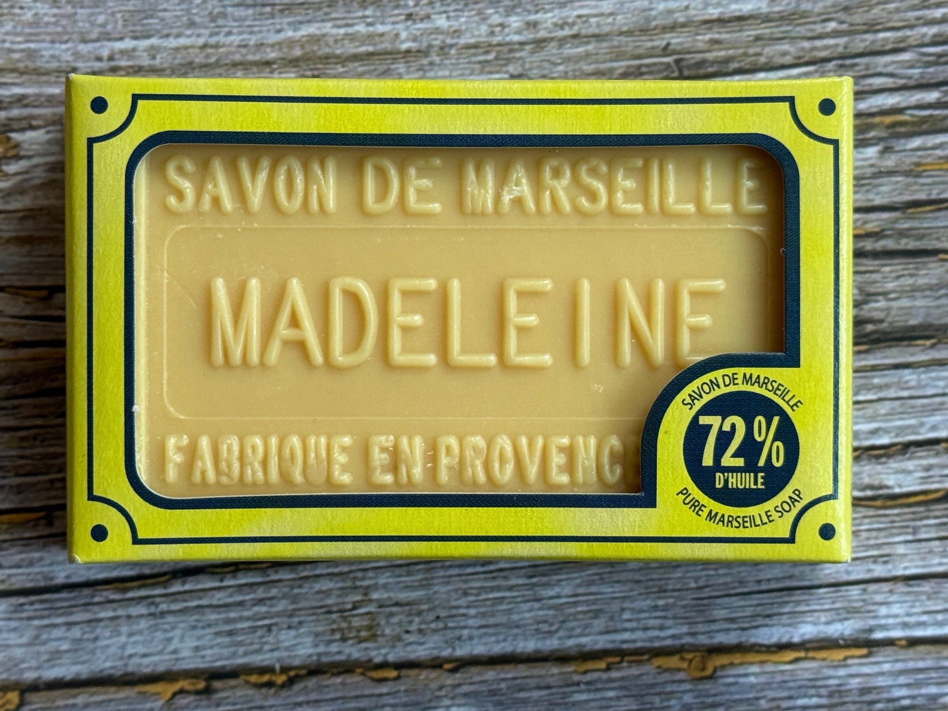 Bar of soap with 'Savon de Marseille Madeleine' packaging on a wooden surface
