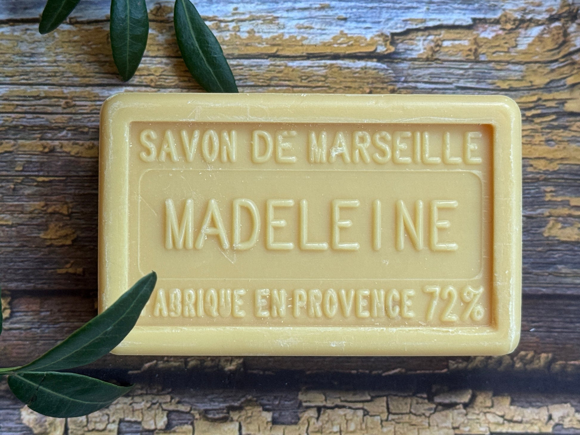 Bar of Savon de Marseille soap with 'Madeleine' branding on a wooden surface.