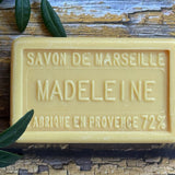Bar of Savon de Marseille soap with 'Madeleine' branding on a wooden surface.