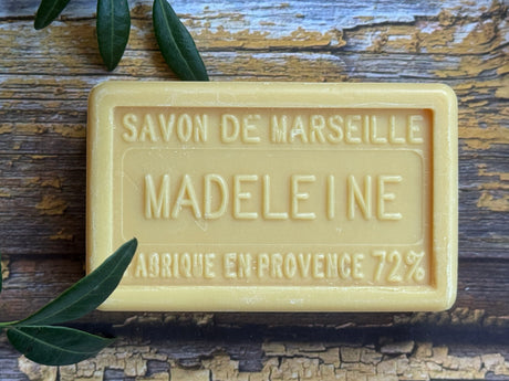 Bar of Savon de Marseille soap with 'Madeleine' branding on a wooden surface.