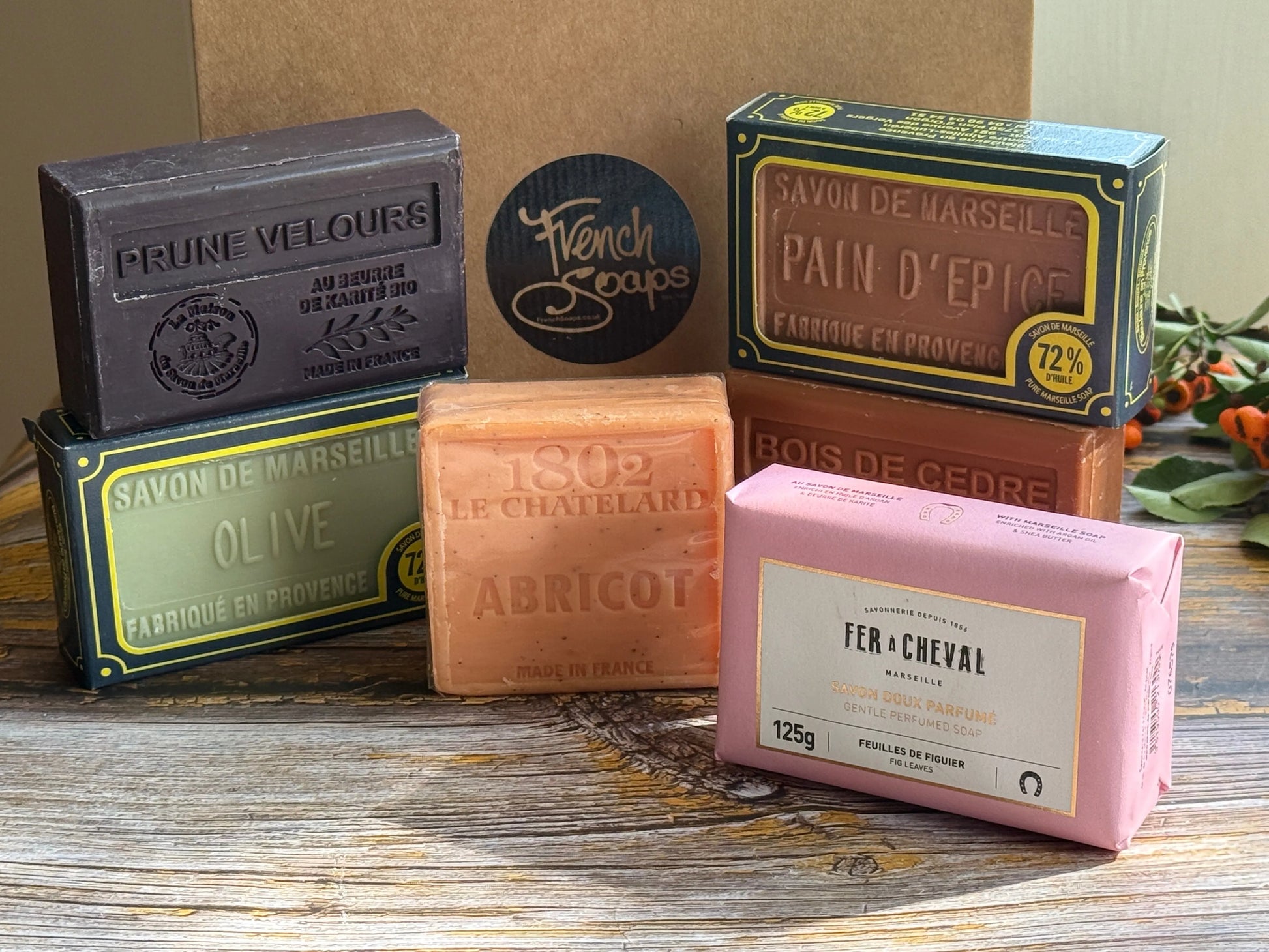 Collection of Marseille soap bars with visible branding on a wooden surface
