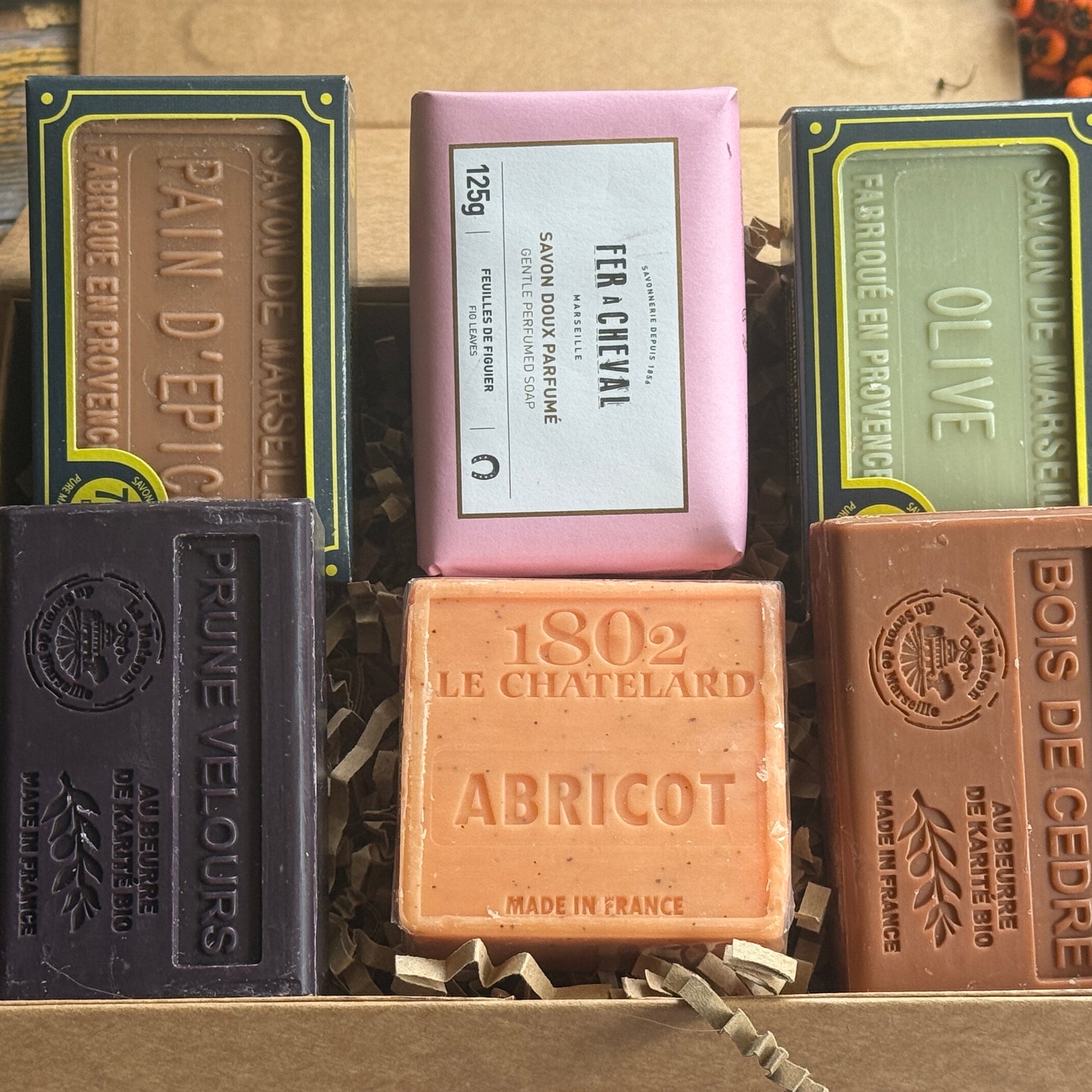 Collection of autumn fragranced soap bars with visible branding in a rustic setting
