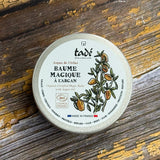 A tub of balm on a wooden surface