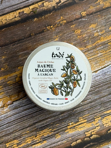 A tub of balm on a wooden surface