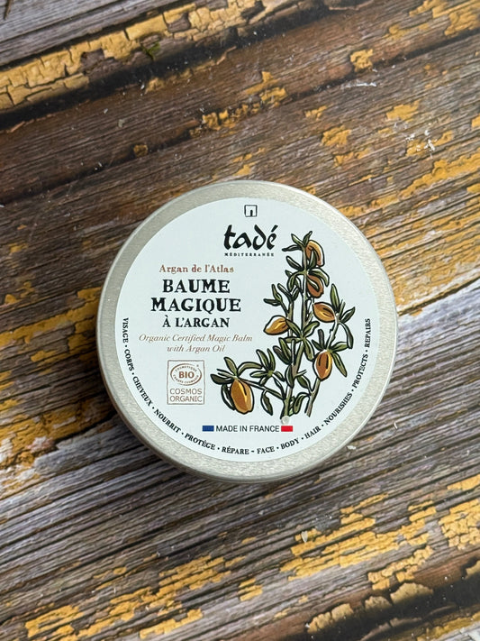 A tub of balm on a wooden surface
