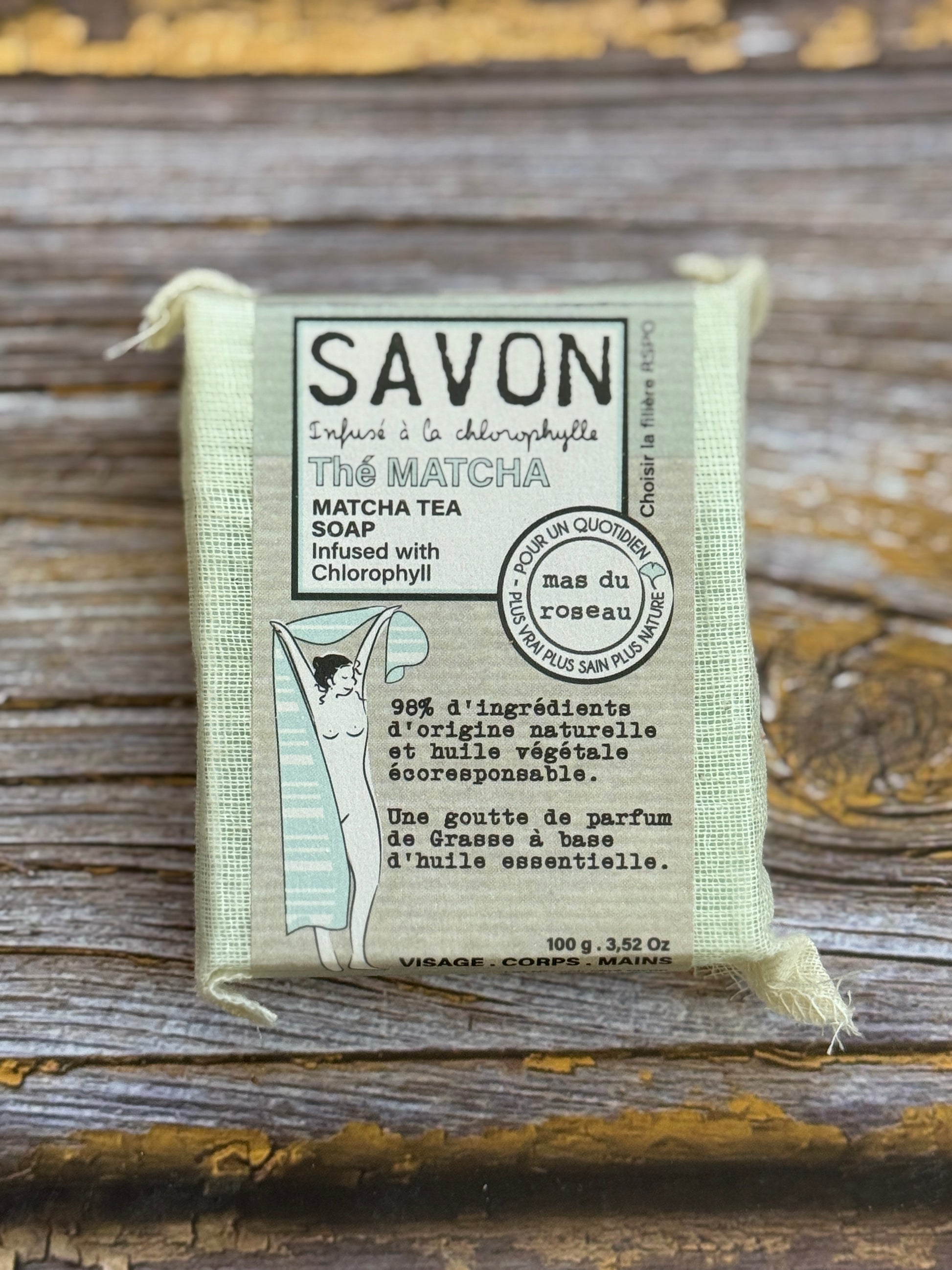 Bar of soap in a packaging with text on a wooden surface