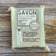 Bar of soap in a packaging with text on a wooden surface
