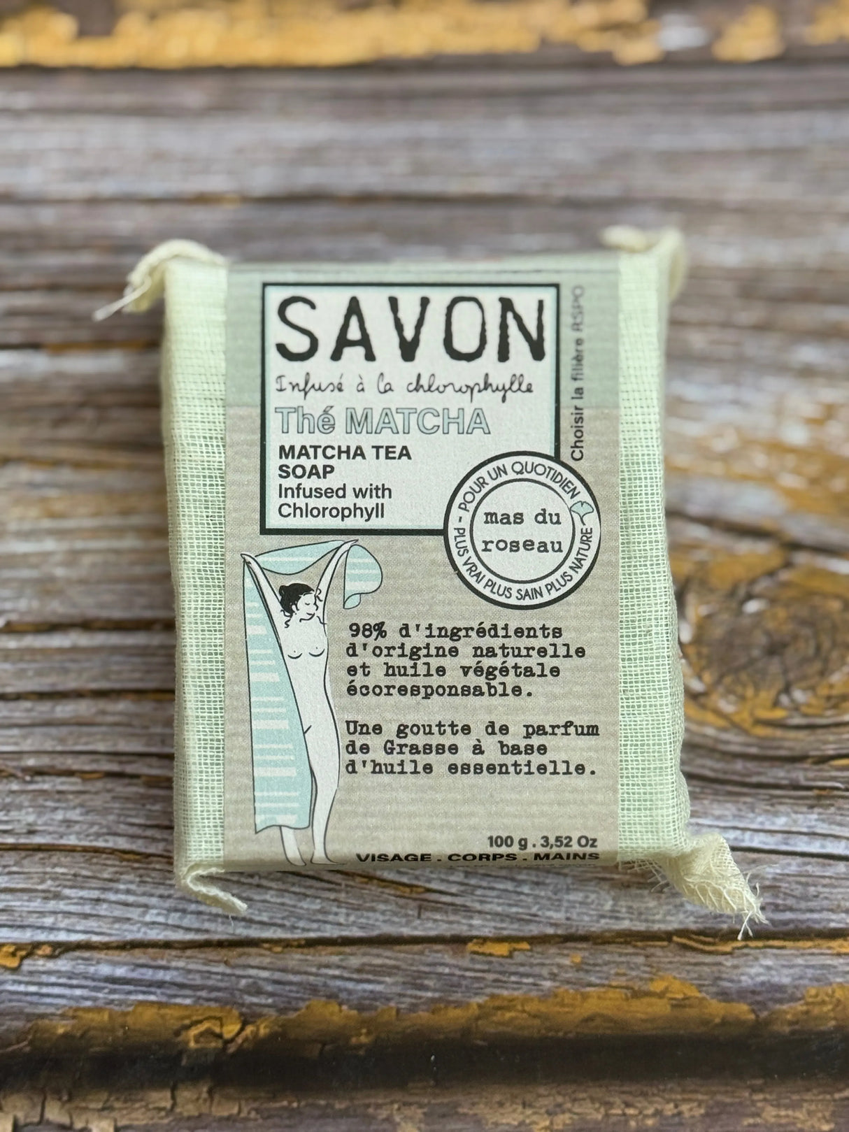 Bar of soap in a packaging with text on a wooden surface