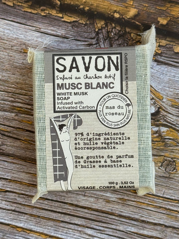 Bar of soap with packaging on a wooden surface