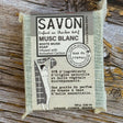 Bar of soap with packaging on a wooden surface