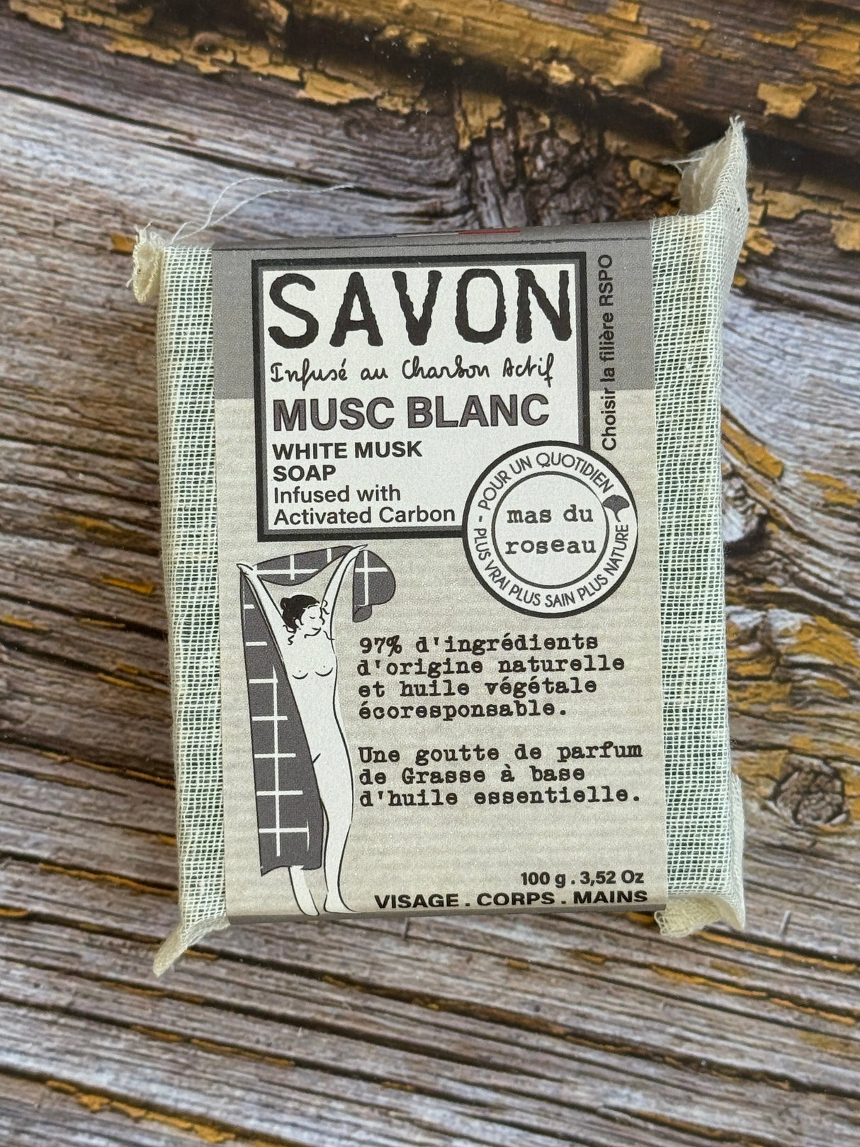 Bar of soap with packaging on a wooden surface