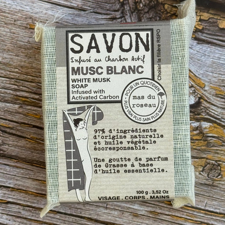 Bar of soap with packaging on a wooden surface