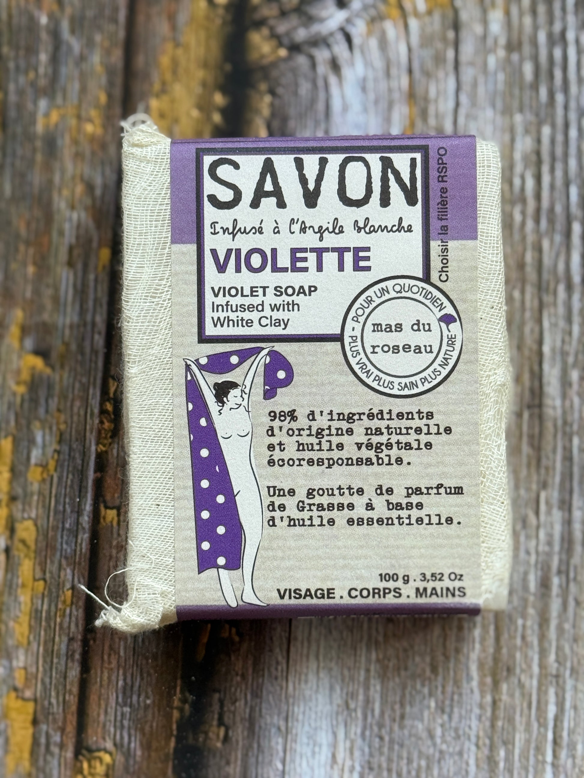 violet Bar of violet soap with packaging on a wooden surface