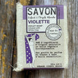 violet Bar of violet soap with packaging on a wooden surface