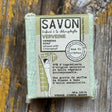 Bar of soap with packaging on a wooden surface