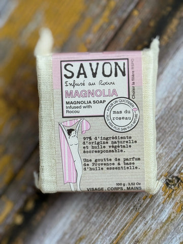 Magnolia Bar of soap with a label on a wooden surface