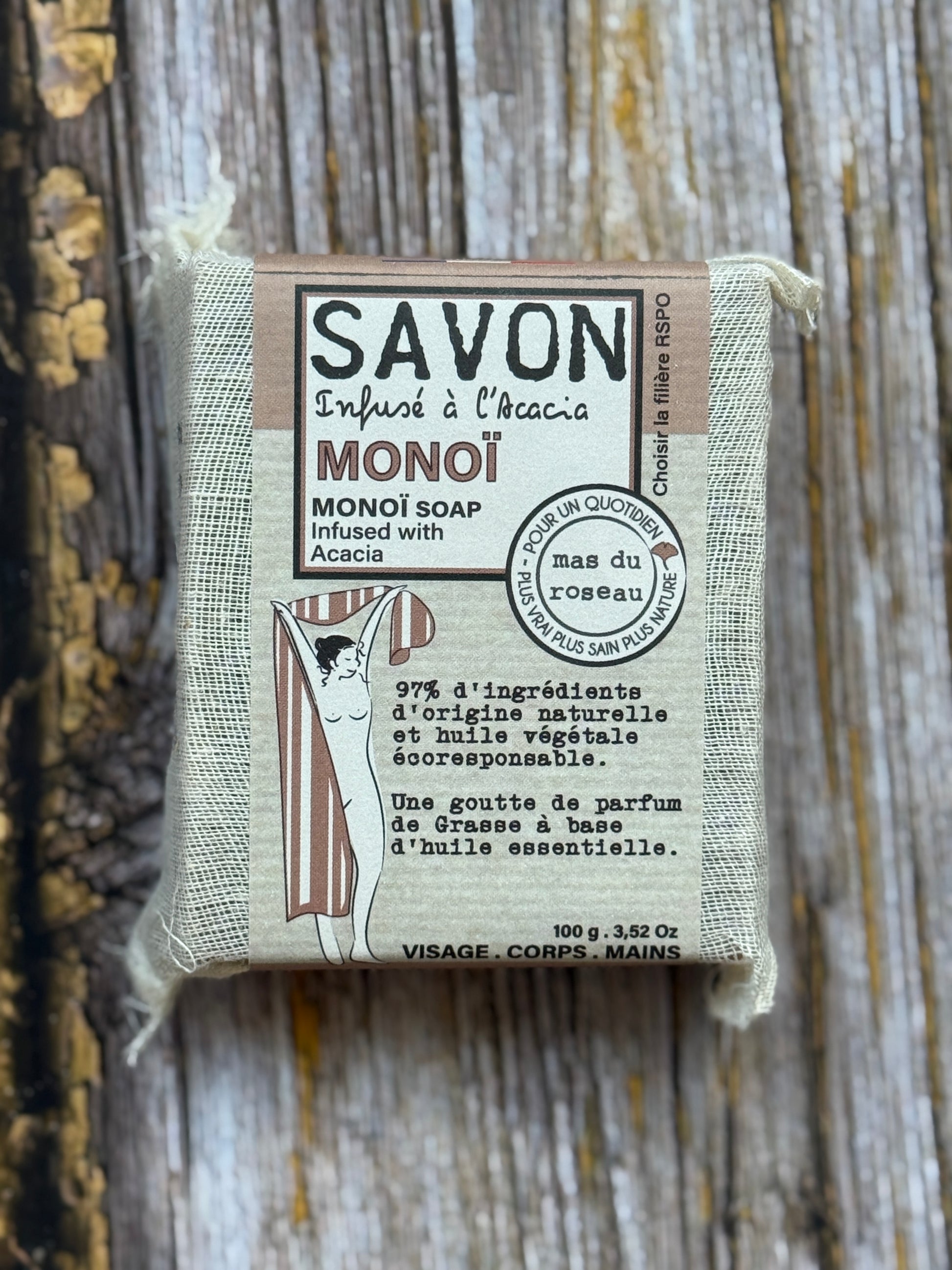 Monoi Bar of soap with a label on a wooden background