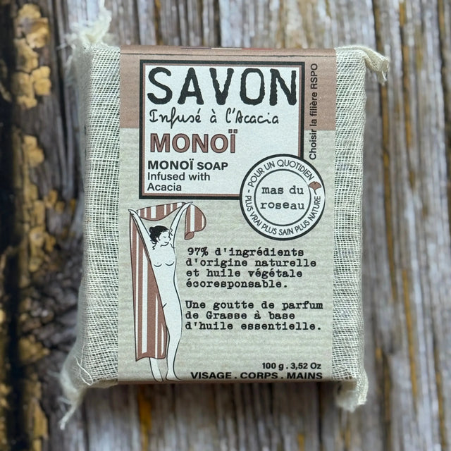 Monoi Bar of soap with a label on a wooden background