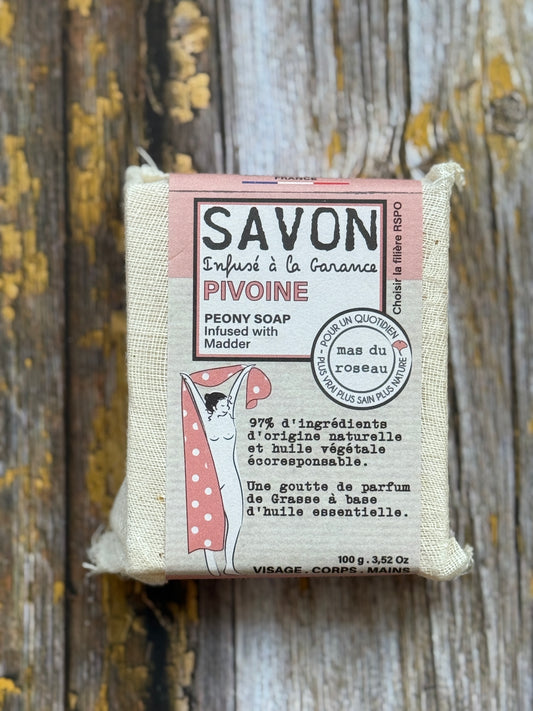 Peony Bar of soap with a pink label on a wooden background