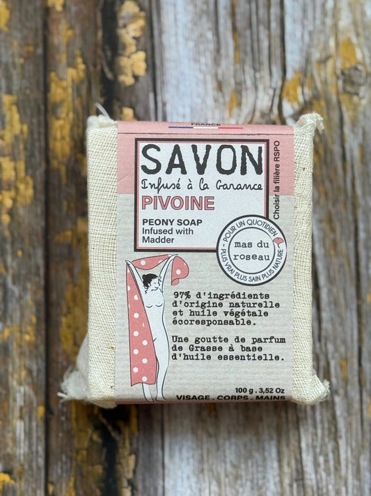 Peony Bar of soap with a pink label on a wooden background