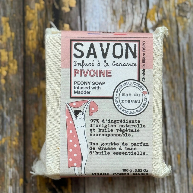 Peony Bar of soap with a pink label on a wooden background