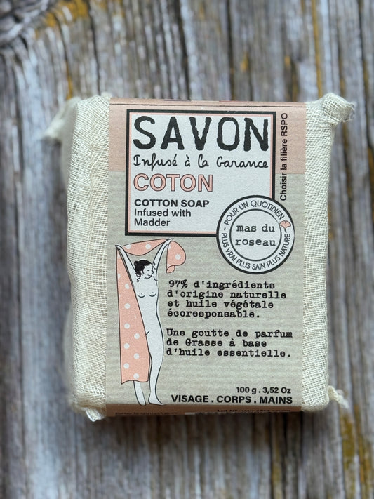 Cotton soap bar with packaging on a wooden surface