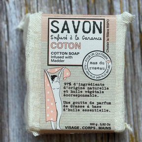 Cotton soap bar with packaging on a wooden surface