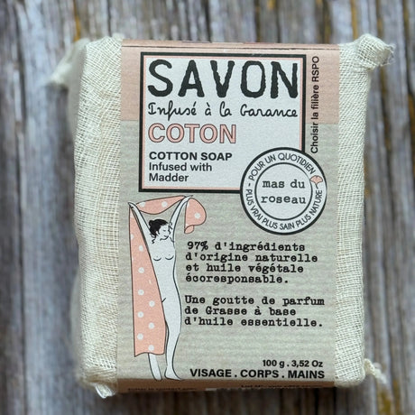 Cotton soap bar with packaging on a wooden surface