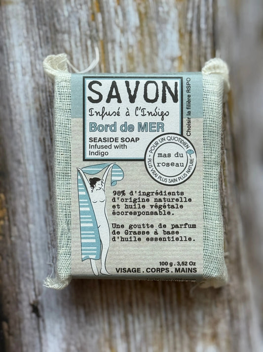 Bar of soap with packaging labeled 'Savon' on a wooden background