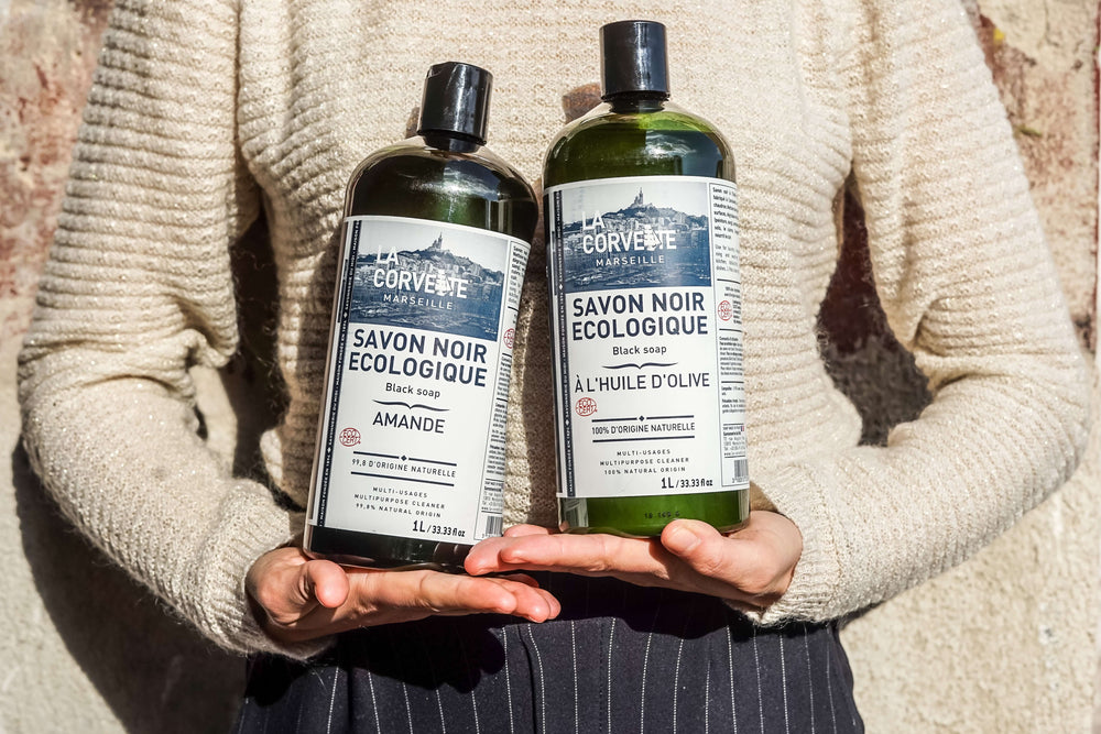Two bottles of La Corvette Savon Noir Ecolégique soap held by a person against a neutral background. French Soaps UK