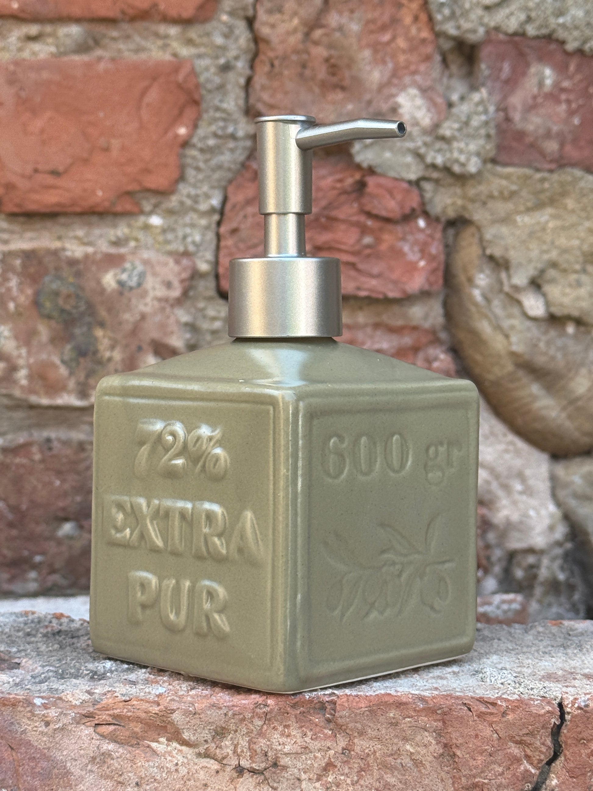 Vintage-style soap dispenser with 'Extra Pur' text on a textured wall background